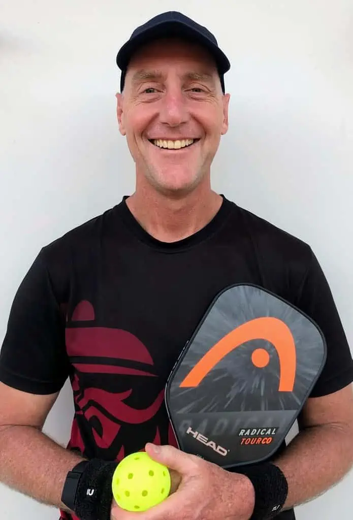 Grant Charge holding a pickleball paddle and pickleball